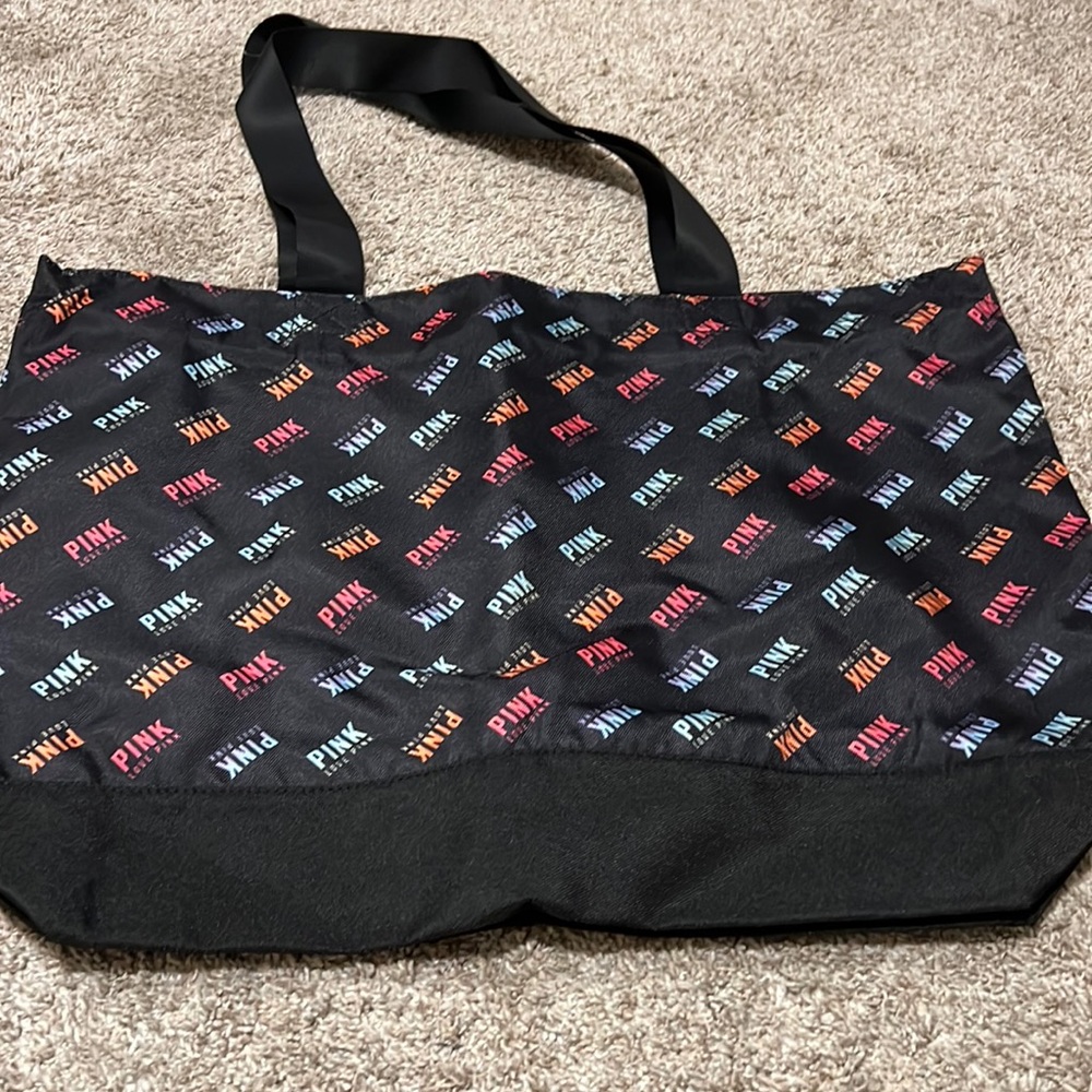 NWT pink bag.  Black base color with multi colored pink name. Zipper bag